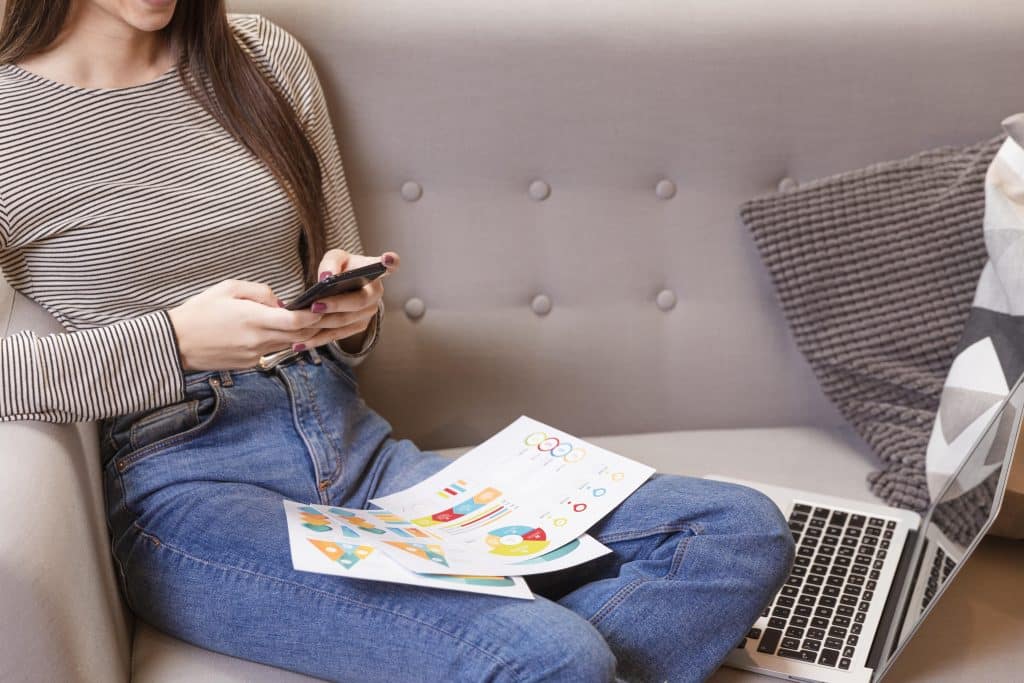 Consumer using a smartphone while reviewing social commerce content and shopping information.